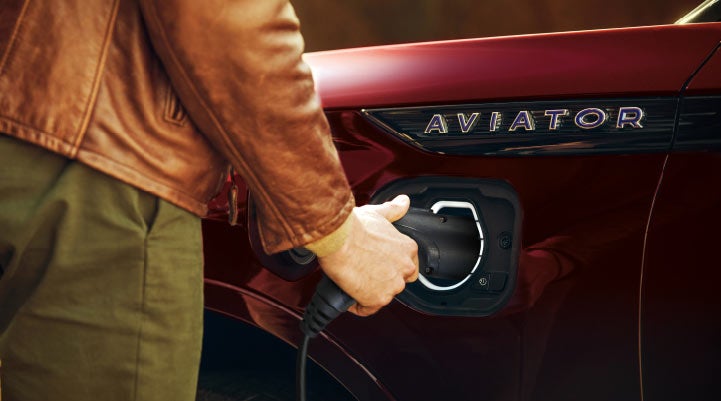 A hand is shown plugging in the charger into the charging port of a 2021 Lincoln Aviator | Gettel Lincoln in Punta Gorda FL