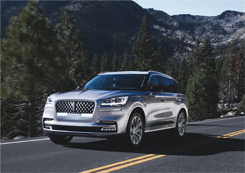 A 2023 Lincoln Aviator® Grand Touring SUV being driven on a winding road to demonstrate the capabilities of all-wheel drive | Gettel Lincoln in Punta Gorda FL